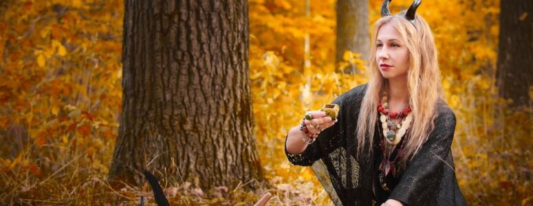 Woman engaging in witchcraft ritual outdoors.