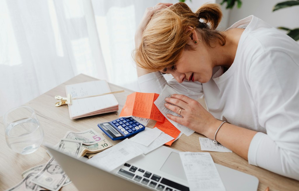 A woman calculating her budget and monthly living expenses so she can calculate how much to save. 